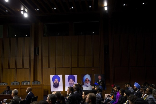 Photographs of the victims of the attack line the walls during a hearing on Capitol Hill on Sept. 19, 2012.