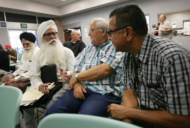 Santokh Singh Sahi, second from left, speaks with John Shaffer, middle, from Riverside, and Dennis Gutierrez, a community liaison with the Riverside County Sheriff's Department, before the start of a meet-greet with members of the Sikh community, on Tuesday, Sept. 10, 2013 at the Glen Avon Library. 