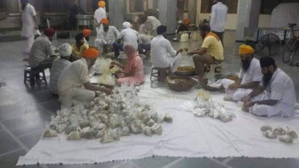 Sikh devotees packing food for flood victims