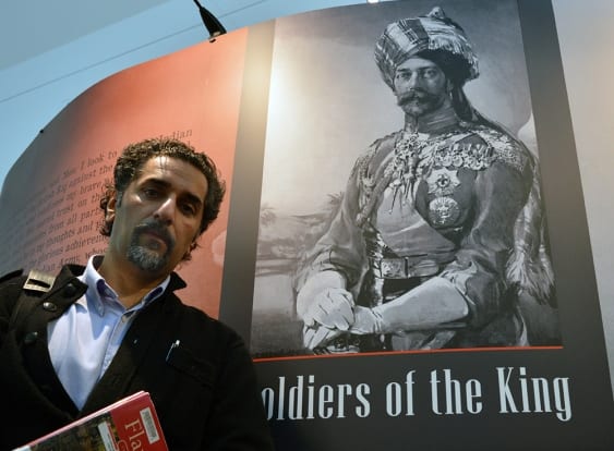 Surrey resident Steven Purewal has put together an exhibit commemorating the involvement of Punjabi soldiers in WWI. Pictured behind Purewal is King George V wearing a ceremonial turban. (Photo: KRISTI ALEXANDRA) 