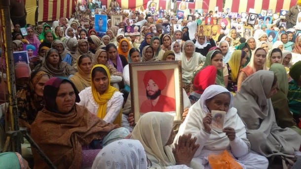 Members of families of martyrs displaying portraits of martyrs.