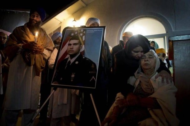 Kulbinder Kaur comforts her mother Sukhwinder Kaur, 73, as she sits next to a photograph of her son Parminder Singh Shergill, outside the Deshmesh Darbar Sikh Temple in Lodi.