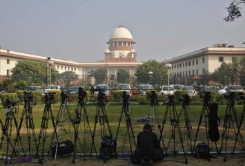 A television journalist sets his camera inside the premises of the Supreme Court in New Delhi February 18, 2014. India's Supreme Court commuted death sentences on three men for involvement in the killing of former prime minister Rajiv Gandhi to life imprisonment on Tuesday because of an 11-year delay in deciding on their petitions for mercy. Gandhi was killed by an ethnic Tamil suicide bomber while campaigning in an election in the southern Indian town of Sriperumbudur in May 1991. REUTERS/Anindito Mukherjee (INDIA - Tags: CRIME LAW POLITICS) - RTX1912P