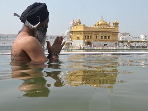A devotee taking bath in the holy sarovar at the Golden Temple in Amritsar on September 14.