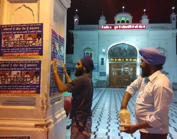 Sikh activists pasting posters on walls