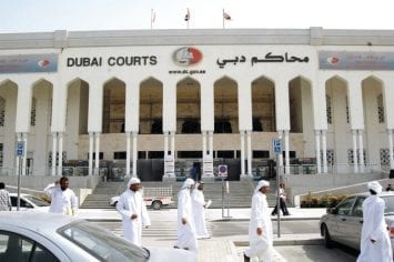 People are seen walking outside the Dubai Courts, where a British couple accused of public indecency, are to be tried in Dubai, United Arab Emirates, Tuesday, Sept. 9, 2008. A court official said Tuesday that the hearings in the trial of a British couple accused of having sex on a Dubai beach have been postponed for another month. (AP Photo/Aziz Shah)