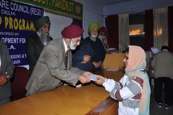 Amar Jit Singh Sodhi distributing a check for scholarship to a student during his recent visit in Punjab